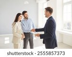 Family couple shakes hands with a real estate agent or realtor, sealing an agreement on a new home purchase. Handshake represents trust and the successful finalization of a property deal.