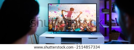 Family Couple Watching TV Or Movie On Couch