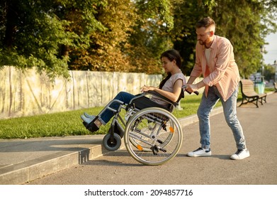 Family Couple With Wheelchair Overcomes The Curb