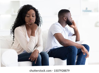 Family Crisis. African American Couple Sitting On Different Sides Of Couch After Quarrel