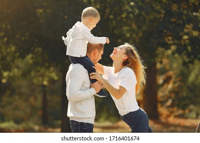 Family with cute little son. Father in a white sweater. Lady in a white t-shirt.