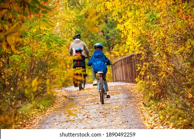 Family Cycling In Golden Autumn Park, Active Father And Kids Ride Bikes, Family Sport And Fitness Outdoors
