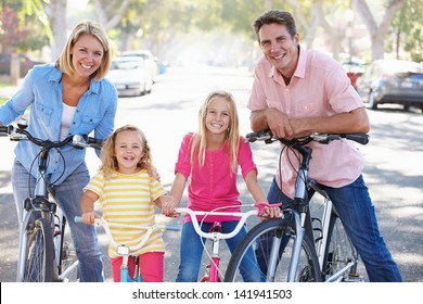 Family Cycling On Suburban Street