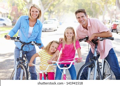 Family Cycling On Suburban Street