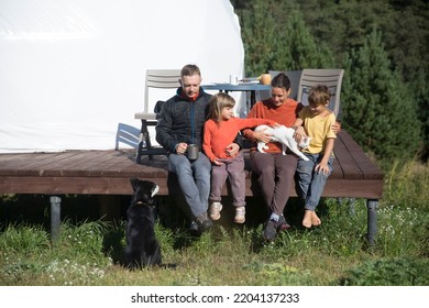 Family Dad, Mom And Two Kids With Dog Ant Cat Rests Outdoor In Glamping House.  Weekend Getaway At Glamping.