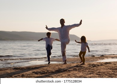 Family  dad and two kids practice Tai Chi Chuan in the summer on the beach. solo outdoor activities. Social Distancing. family exercising  together  - Powered by Shutterstock