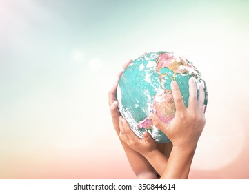 Family Day concept: Children hands holding earth globe over blurred abstract nature background. Elements of this image furnished by NASA - Powered by Shutterstock