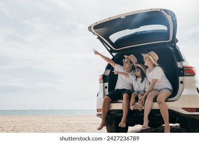 Family Day. Father, Mother and daughter enjoying road trip sitting on back car and point finger out blue sky, Happy people having fun in summer vacation on beach, Family travel in holiday at sea beach - Powered by Shutterstock