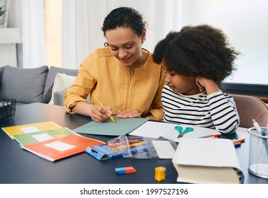 Family Day. Mother Helps Her Daughter Do School Homework While Father Works On His Laptop. Happy Family, Home Comfort