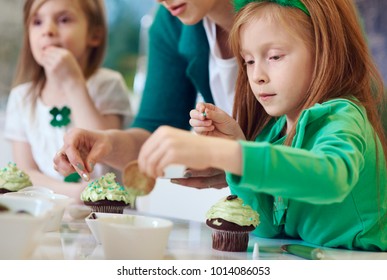 Family Decorating Cupcakes At Kitchen 