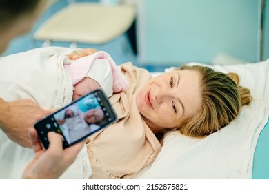 Family In The Delivery Ward. Supportive Father Making Firstb Photo Of His Baby And Wife.