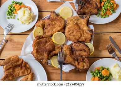 Family Dinner Table With Breaded Pork Chops, Mashed Potatoes And Vegetables.