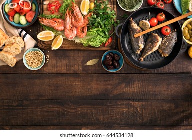 Family Dinner Table With Shrimp, Fish Grilled, Salad, Different Snacks With Border, Top View