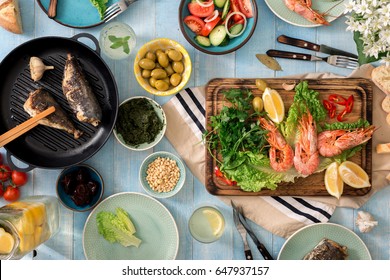 Family Dinner Table With Shrimp, Fish Grilled, Salad, Different Snacks And Homemade Lemonade, Top View