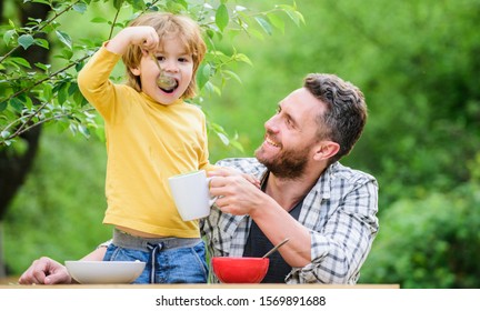 family dinner time. father and son eating outdoor. happy fathers day. Little boy with dad eat cereal. Morning breakfast. Vegetarian diet. healthy food and dieting. Dairy products. Family bonds. - Powered by Shutterstock