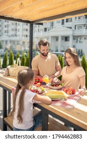 Family Dinner. Young Cute Family Having Dinner Outside And Looking Pleased