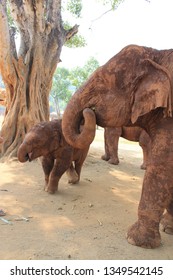 Family Of Dirty Elephants Feeding Themselves, With Baby Elephant