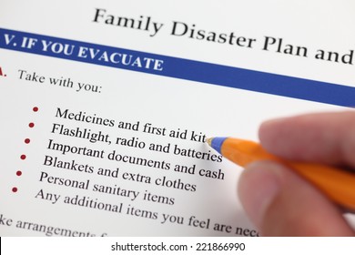 Family Disaster Plan And Hand With Ballpoint Pen. Close-up.