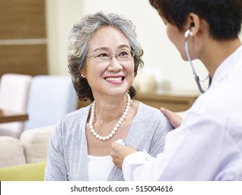 Family Doctor Checking Smiling Senior Asian Woman Using Stethoscope