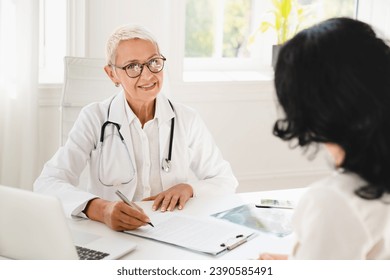 Family doctor general practitioner gynecologist prescribing medicines, health insurance with female patient during hospital appointment - Powered by Shutterstock