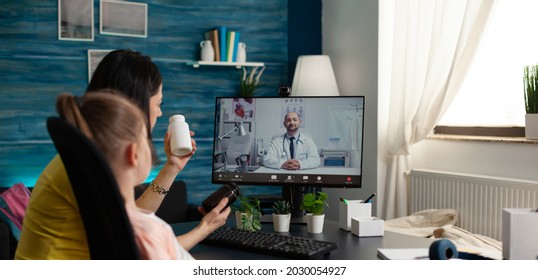Family Doctor Giving Prescription Medicine Consultation On Video Call With Sick Child Patient And Parent At Home. Caucasian People Using Online Conference Meeting App For Healing Treatment