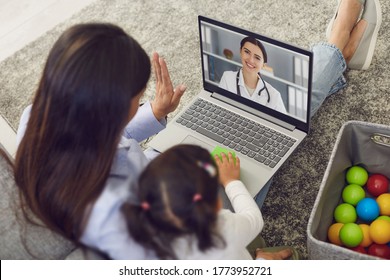 Family Doctor Online. Mother And Baby Greet The Doctor Have A Video Call Laptop To The Doctor At Home.
