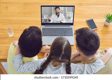 Family doctor online.Parents and a child consult a doctor using a laptop at home.