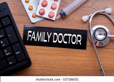 Family Doctor words written on label tag with medicine,syringe,keyboard and stethoscope with wood background,Medical Concept