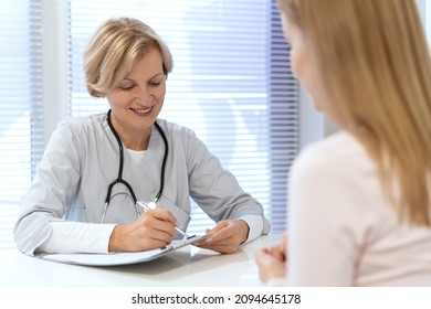 Family Doctor Write Notes In Patient Medical Records, Prescribes Medications, Discuss Treatment Plan For Young Woman. General Practitioner Check Medical Insurance Contract At Office In Private Clinic