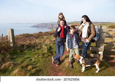 Family With Dog Walking Along Coastal Path