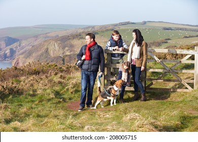 Family With Dog Walking Along Coastal Path