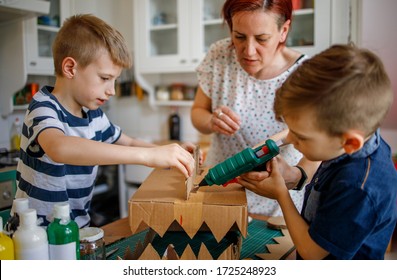 Family Doing Fun Project At Home, Cardboard Dinosaur