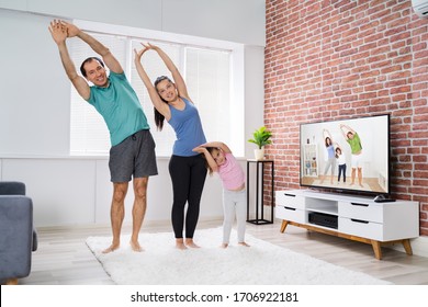 Family Doing Online Stretching Yoga Exercise At Home