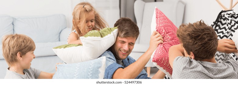 Family Doing A Pillow Fight In Living Room