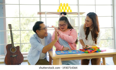 Family downs syndrome Live video clip of Wooden block toy continuation by sharing via smartphone on social media. - Shutterstock ID 1930714364