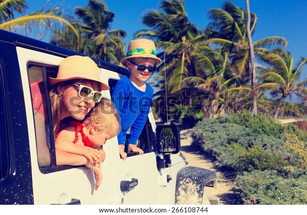 family driving off-road car on tropical beach,\
vacation concept