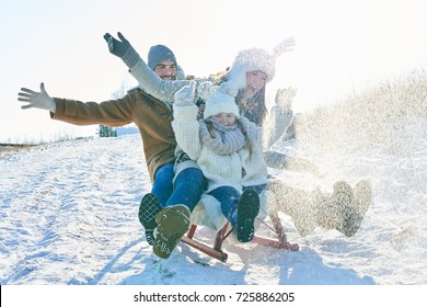 Family driving sled on the snow and having fun in winter