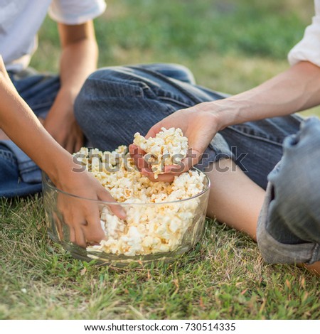 Family eat popcorn in park or backyards, detail