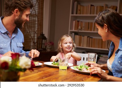 Family Eating Dinner At A Dining Table