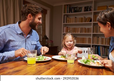 Family Eating Dinner At A Dining Table