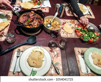 Family Eating Dinner At A Holiday Potluck