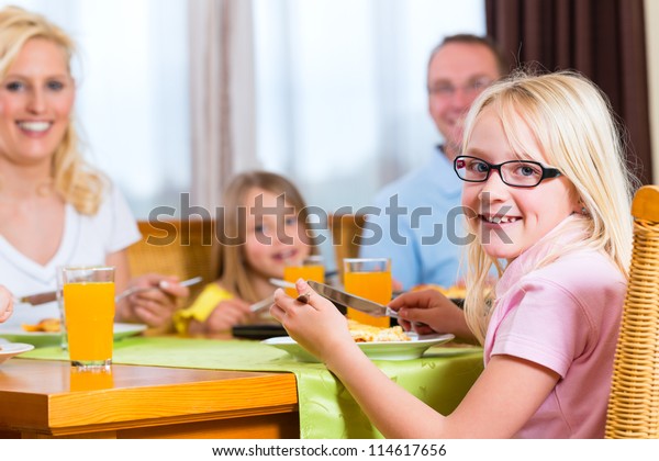 Family\
eating lunch or dinner and sitting at the\
table