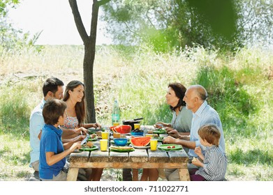 Family Eating Meal On Outdoor Table