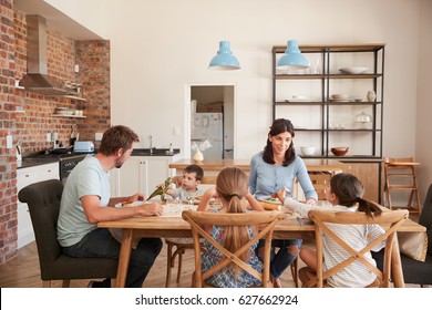 Family Eating Meal In Open Plan Kitchen Together