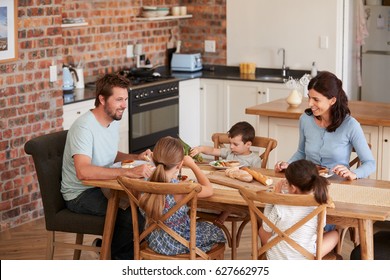 Family Eating Meal In Open Plan Kitchen Together