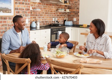 Family Eating Meal In Open Plan Kitchen Together