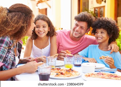 Family Eating Meal At Outdoor Restaurant Together