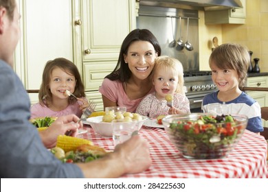 Family Eating Meal Together In Kitchen