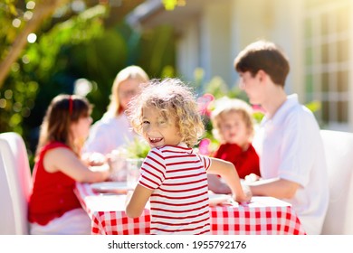 Family Eating Outdoors. Garden Summer Fun. Barbecue In Sunny Backyard. Grandmother And Kids Eat Lunch In Outdoor Deck. Parents And Children Enjoy Bbq. Boy And Girl With Mother.