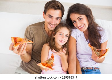 Family Eating Pizza On A Sofa